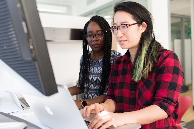 Two ladies on the computer learning how to void a check in QuickBooks 