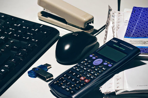 bookkeeper organize client files at desk with office supplies