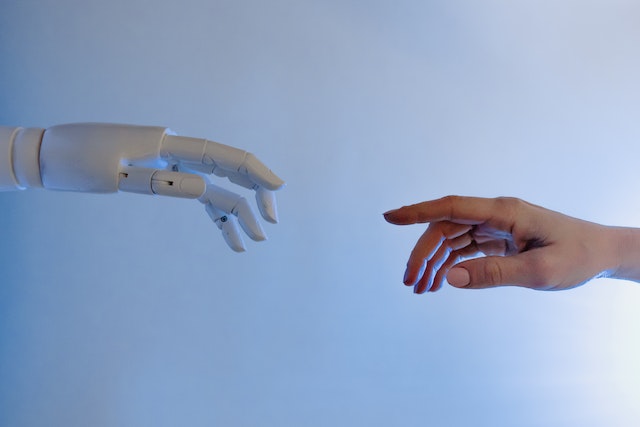 Hands touching in human and robot form. 