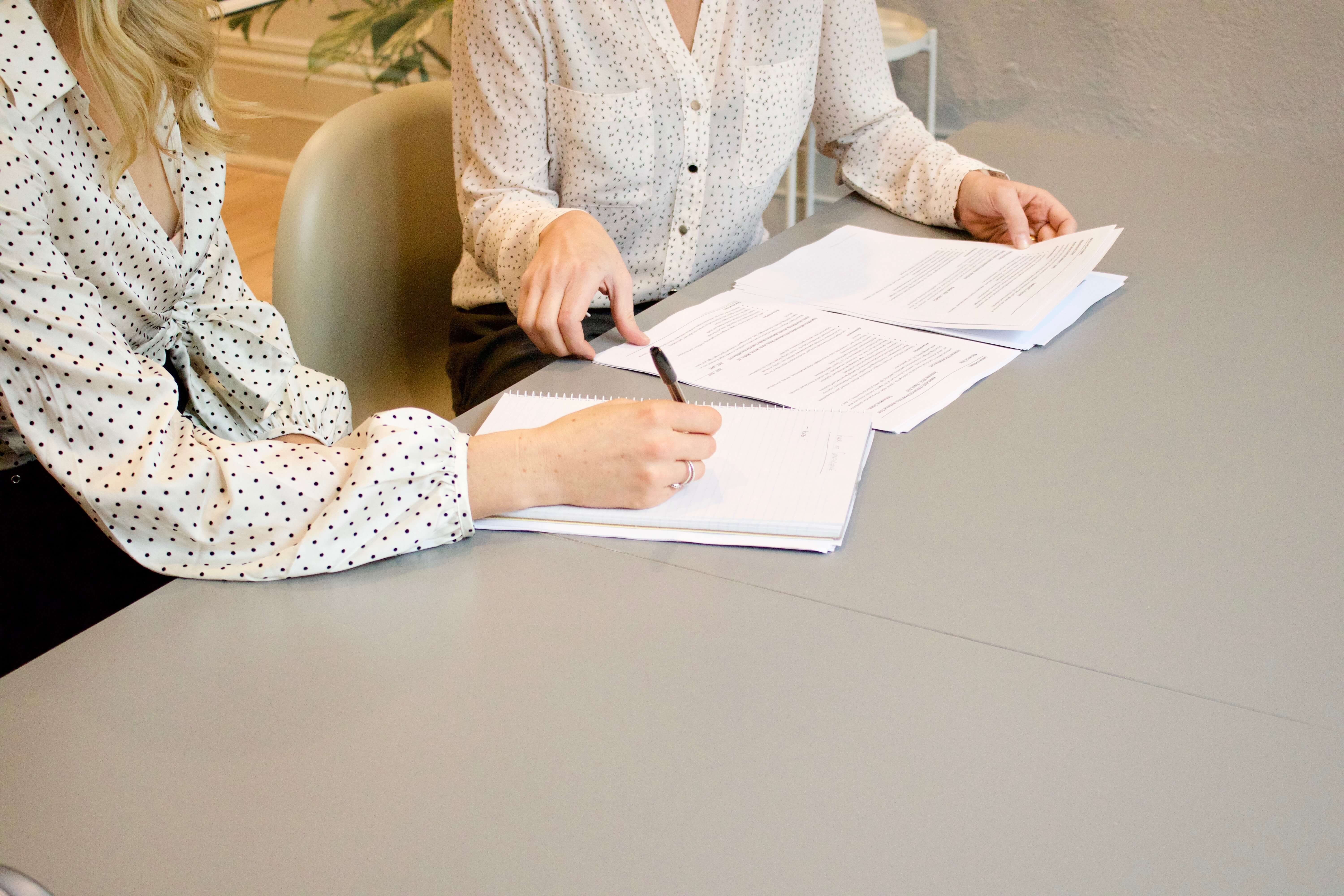 Two women signing legal documents