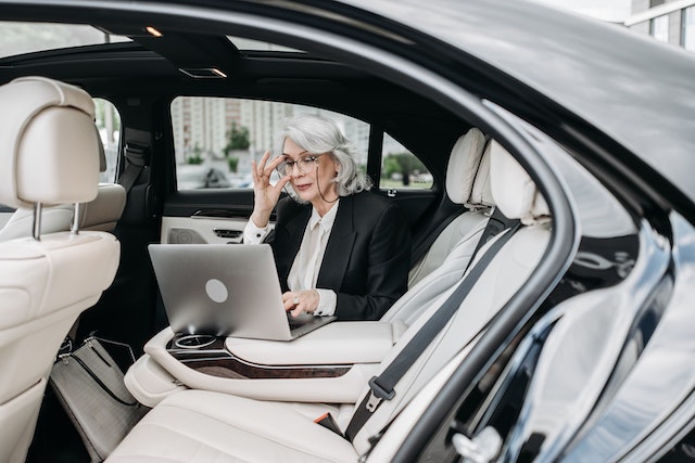 lady in backseat on laptop reviewing how to keep track of business expenses